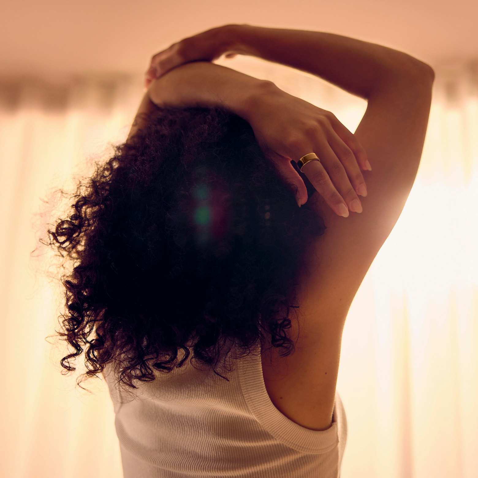 Woman wearing Oura ring stretching hands above head